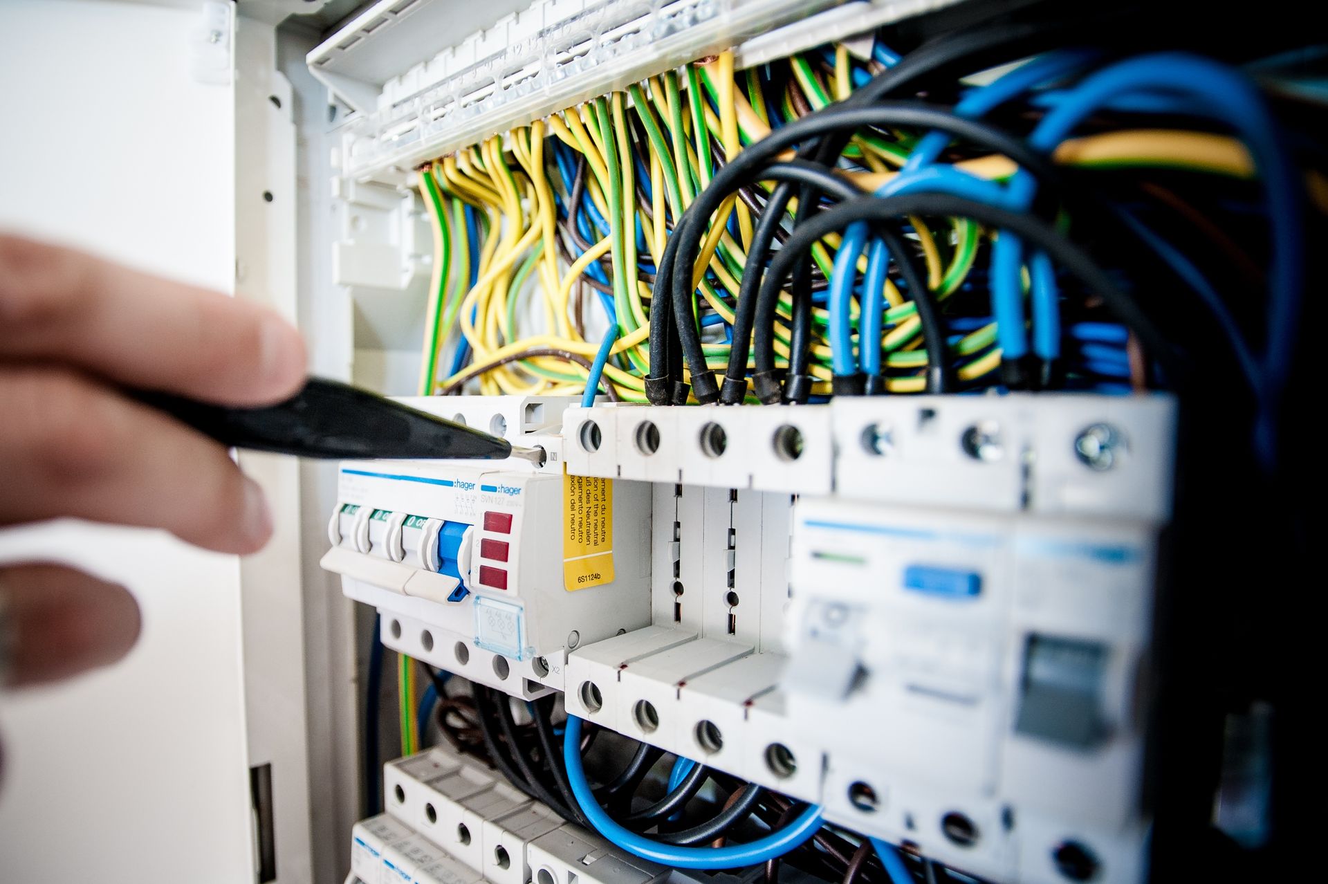 Primer plano de un electricista trabajando en un panel de interruptores